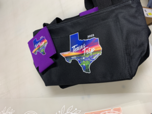 custom color logo on black fanny pack with matching purple koozie